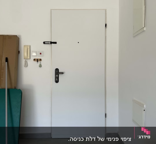 דלת לבנה עם מנעול וחפצים ליד